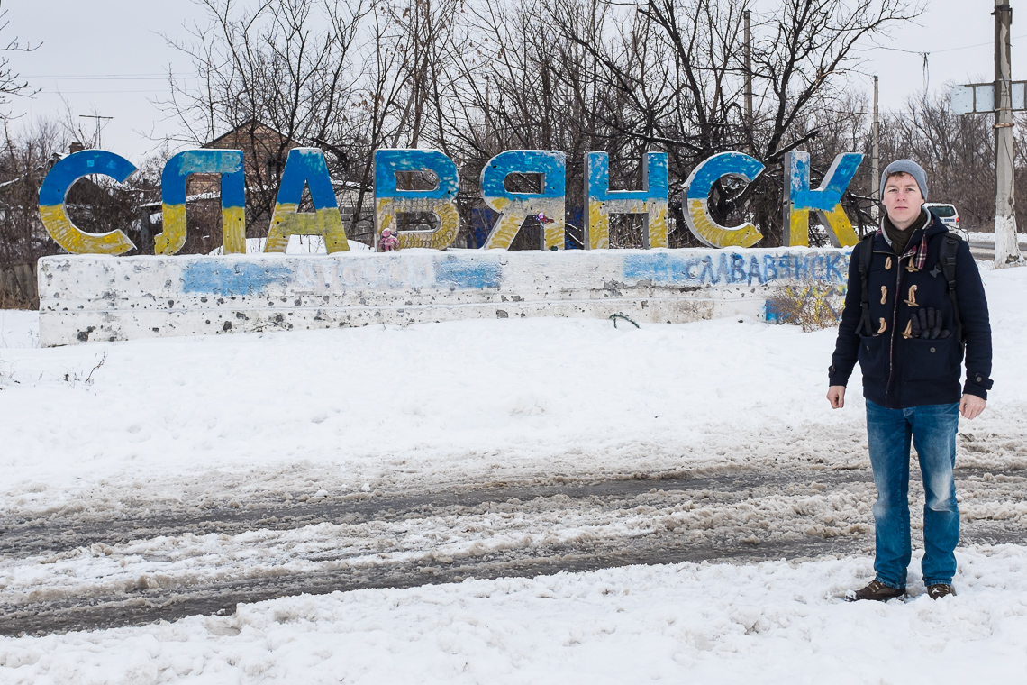 Standing at the scarred sign of Slavyansk city. It was painted in national colors after the separatists had left.
