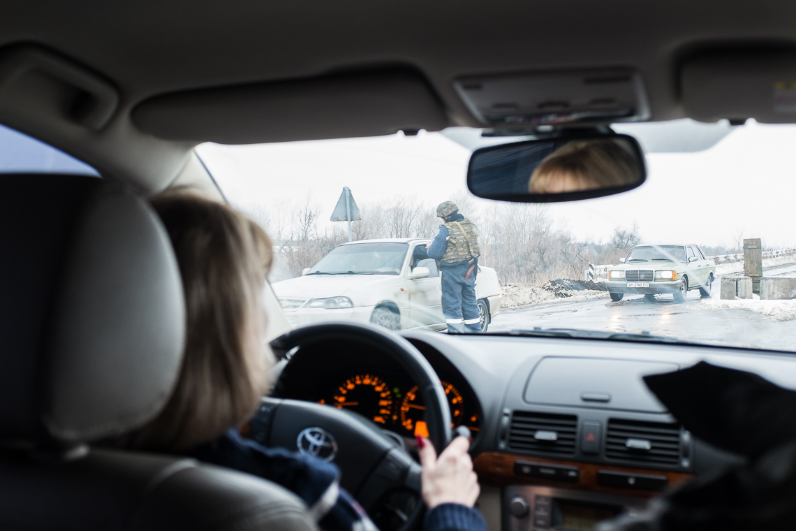 A Ukrainian soldier checks a car at a checkpoint