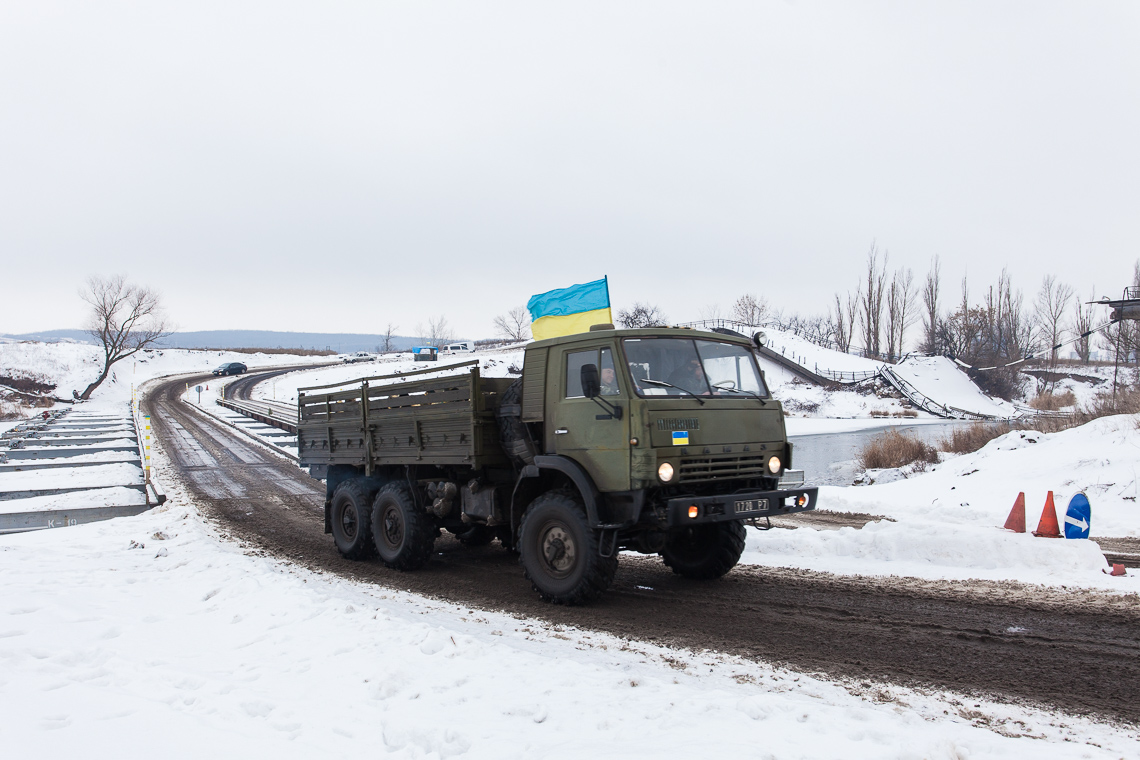 An army truck passes a temporary bridge near Sloviansk