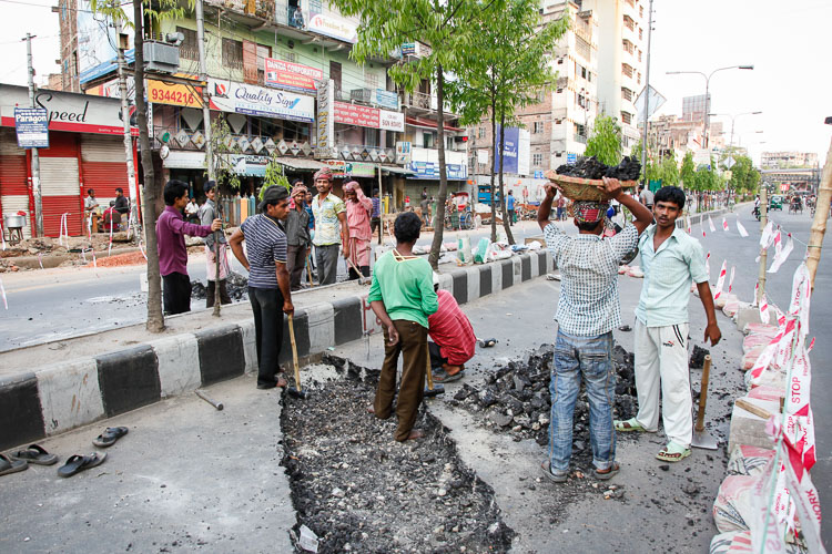 In Dhaka you run into the most astonishing scenes, like these 12 workers hammering down on the bitumen