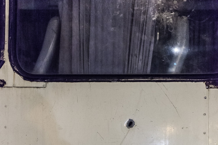 Another bullet hole in a bus parked at Junta. The driver told me the woman in the seat had died.