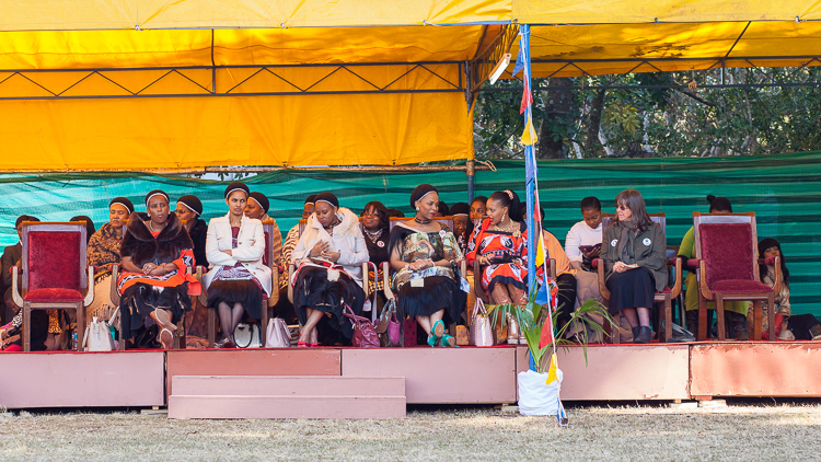 Mswati III's 16 wives, sitting on a separate stage next to the King