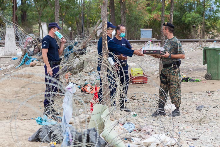 Greek police step into Macedonian territory, handing out cold drinks to the Macedonian army. Much of the order at the border is a direct result of the level of their cooperation, which remains good until today
