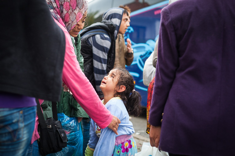A young girl cries as a small chaos errupts when people try to get on buses that will take to the border with Serbia.