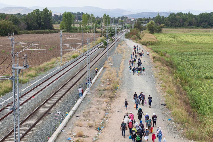 A group of refugees walk along the railway with only 5 kilomters left on their way to the border Greece-Macedonia