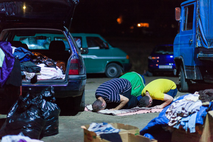 Albanian Macedonian volunteers pray at the Tabanovce train station. They are there every day during the night, donating food and clothes to predominantly Muslim refugees.