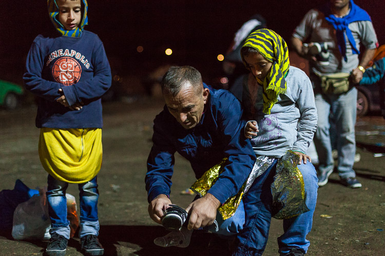 As children are arriving near the Macedonia-Serbia border at Tabanovce, volunteers from the town Studenichani fit new shoes, socks and clothes to the children. They are often freezing, wet and scared, arriving in the mid of night from the refugee camp in Gevgelija