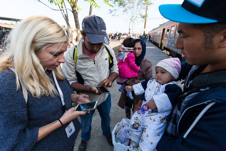 A Macedonian volunteers explains to some Afghan refugees how to travel into the EU through Croatia as news poored in that Hungary had sealed off its borders.