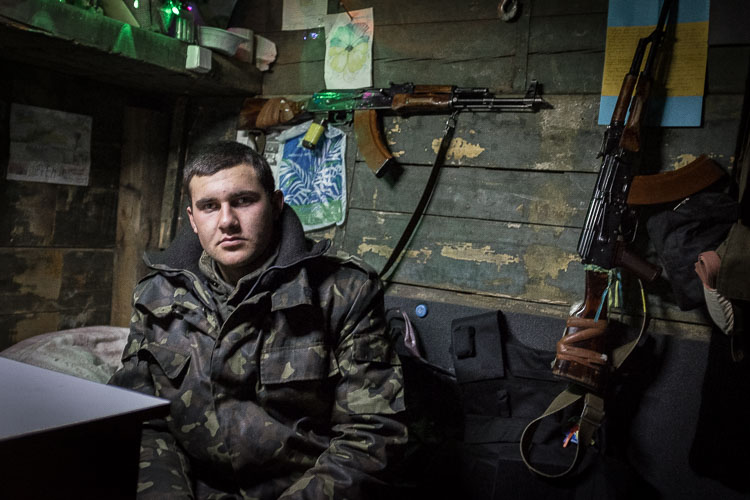 A Ukrainian soldier sits inside a heated barrack, which is set up next to a blown-up bridge on the outskirts of Sloviansk in east Ukraine.