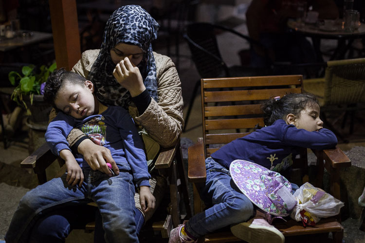 A woman and her two children wait outside the registration camp in Preševo, south Serbia. The husband was inside for hours to obtain the necessary documents to travel onwards to north Europe.