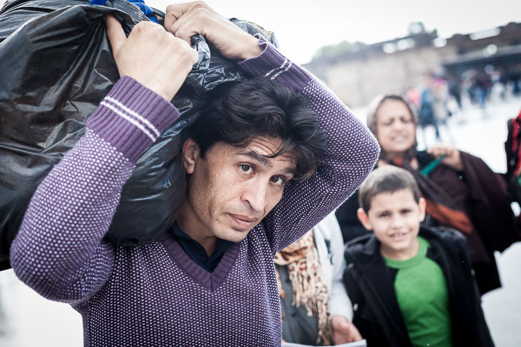 Refugees carrying plastic bags are those who were forced by smugglers in Turkey to dump their belongings in the Aegean sea.